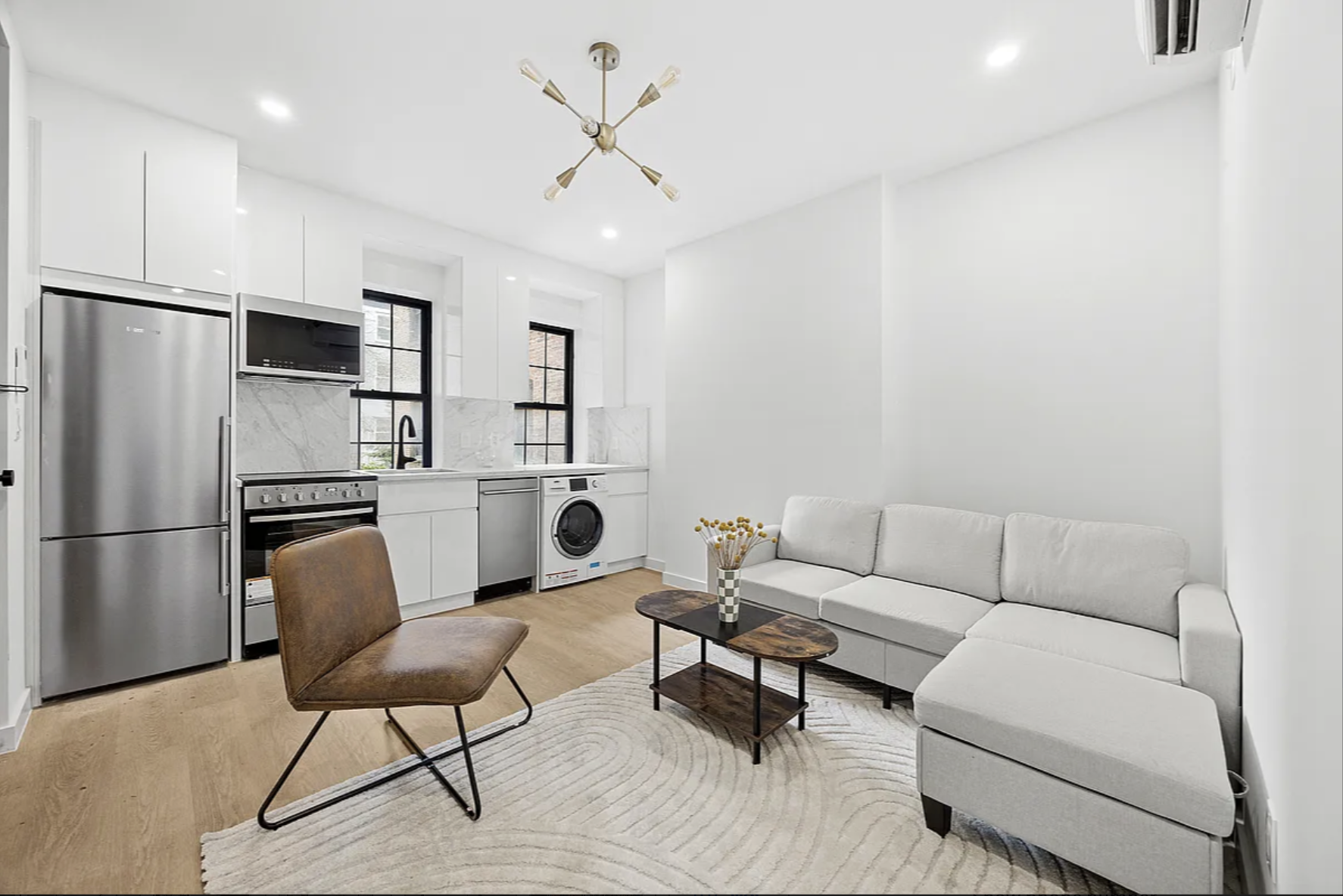 a living room with furniture a refrigerator and kitchen view