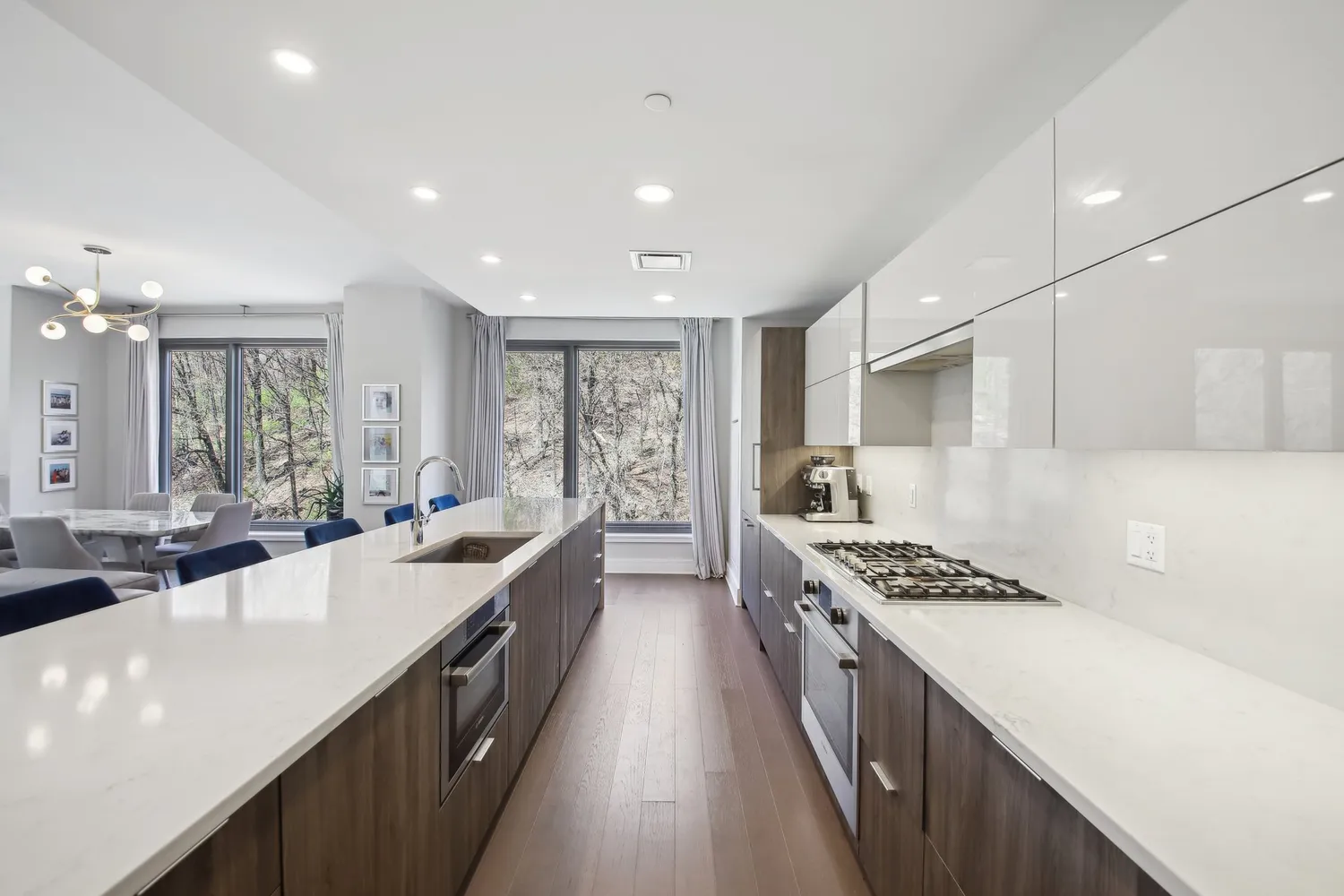 a large kitchen with stainless steel appliances a sink a counter top space a stove and a window