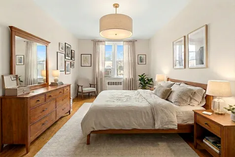 a spacious bedroom with a bed and a dresser