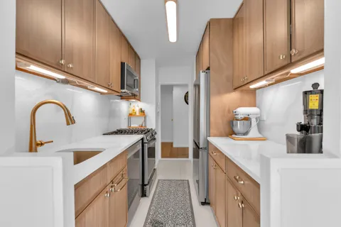 a kitchen with sink a refrigerator and cabinets