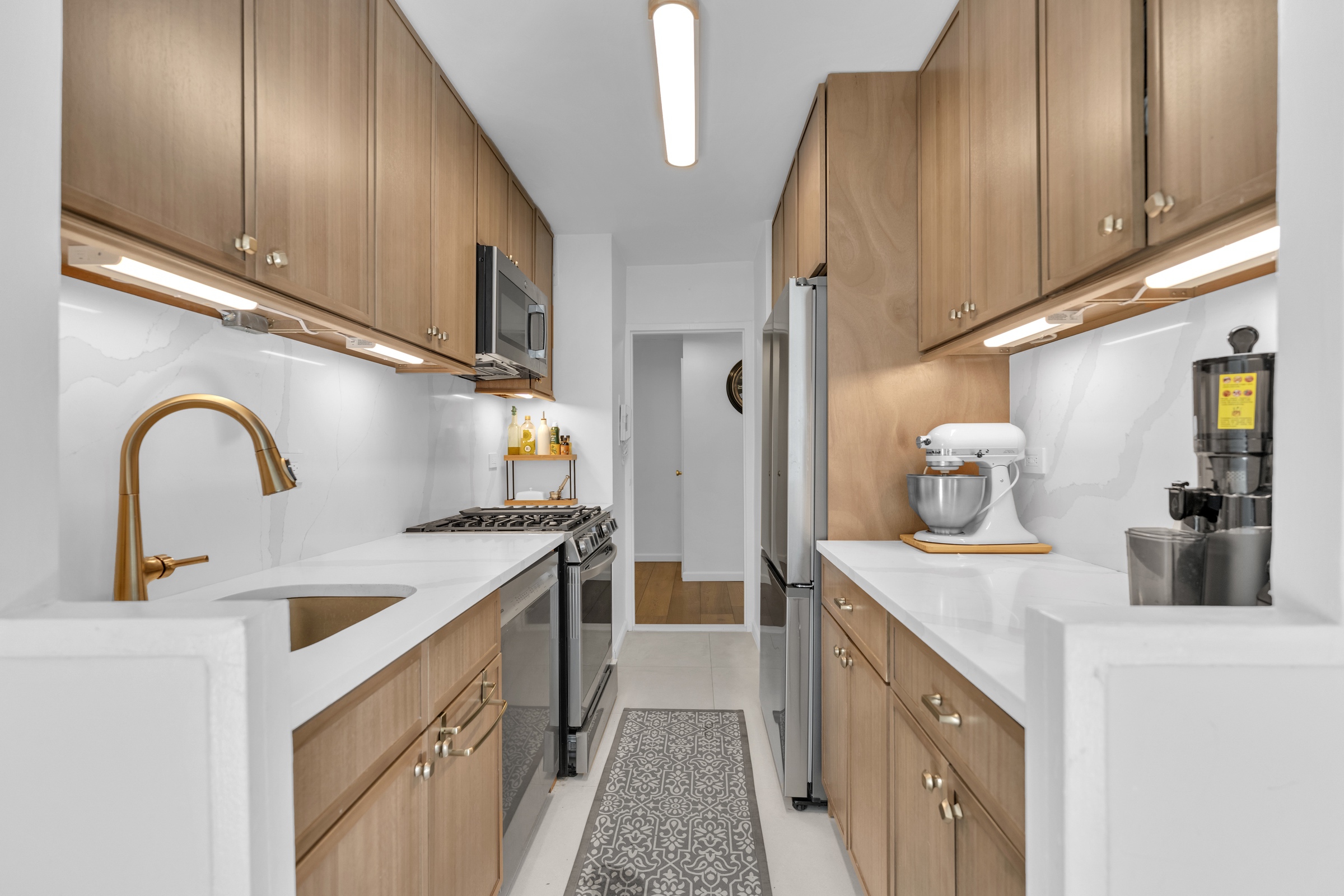 150 West End Avenue, Unit 21M Manhattan, NY 10023 - Photo 4 of 13 a kitchen with sink a refrigerator and cabinets