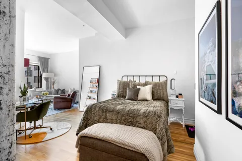 a bedroom with a bed and dresser with mirror