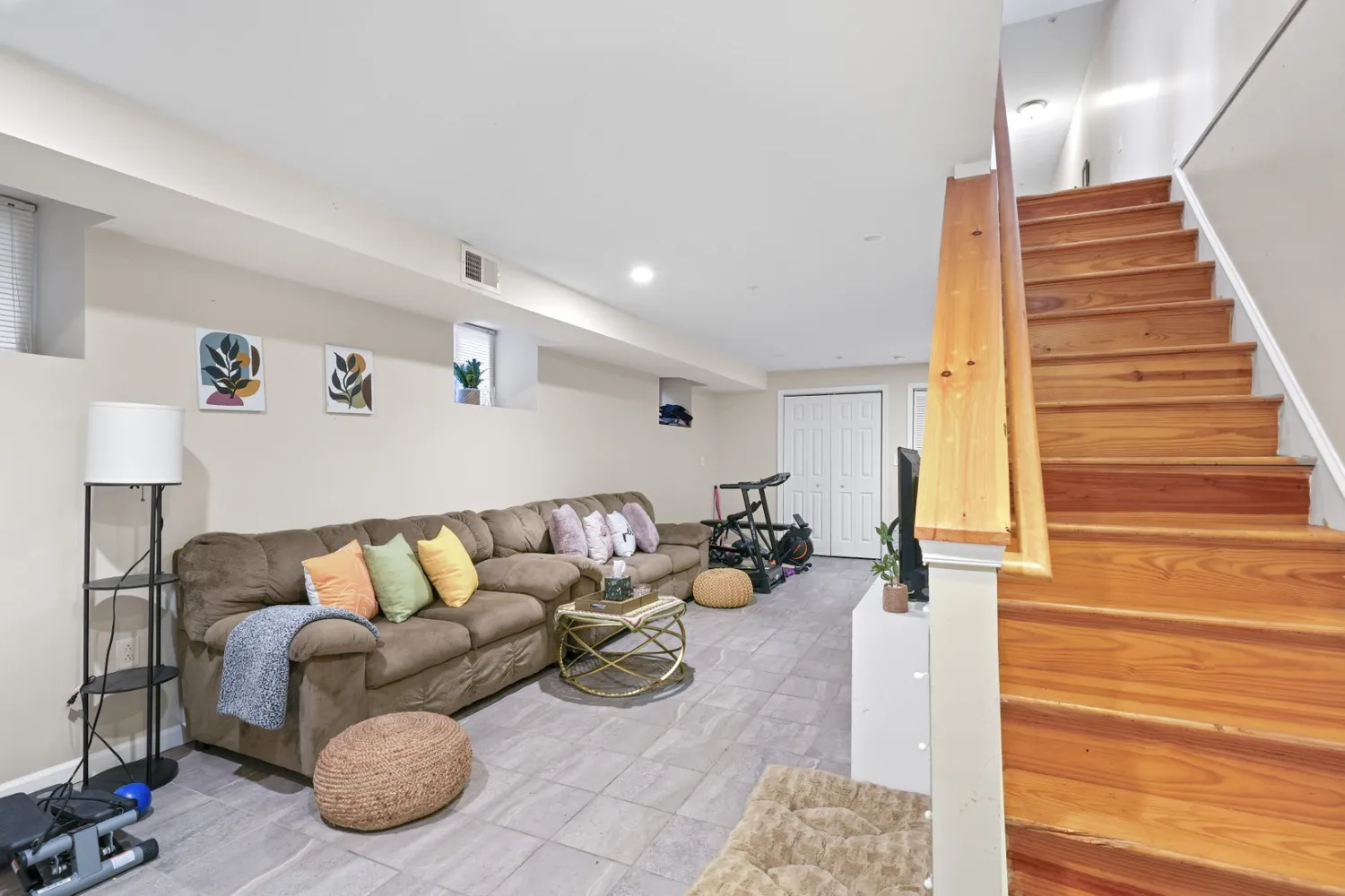 a living room with furniture a flat screen tv and a potted plant