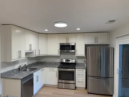 a kitchen with granite countertop stainless steel appliances and wooden cabinets