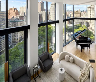 a living room with furniture and a floor to ceiling window
