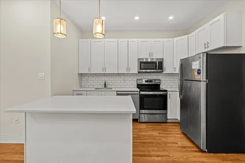 a kitchen with granite countertop a refrigerator stove and microwave