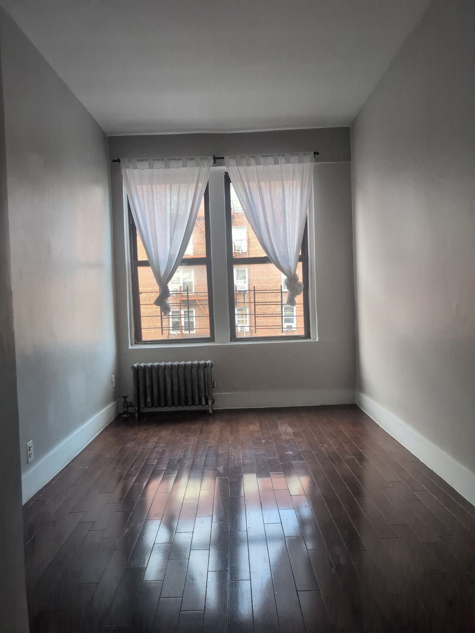 2405 Nostrand Avenue, Unit 6 Brooklyn, NY 11210 - Photo 6 of 11 an empty room with wooden floor and windows