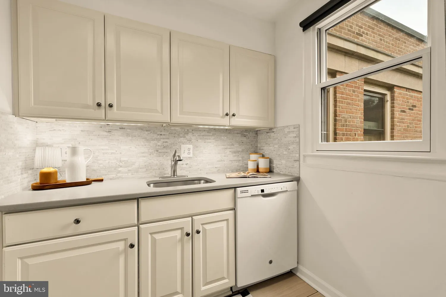 a kitchen with stainless steel appliances granite countertop white cabinets and a sink