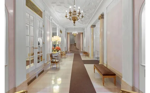 a lobby with furniture and chandelier