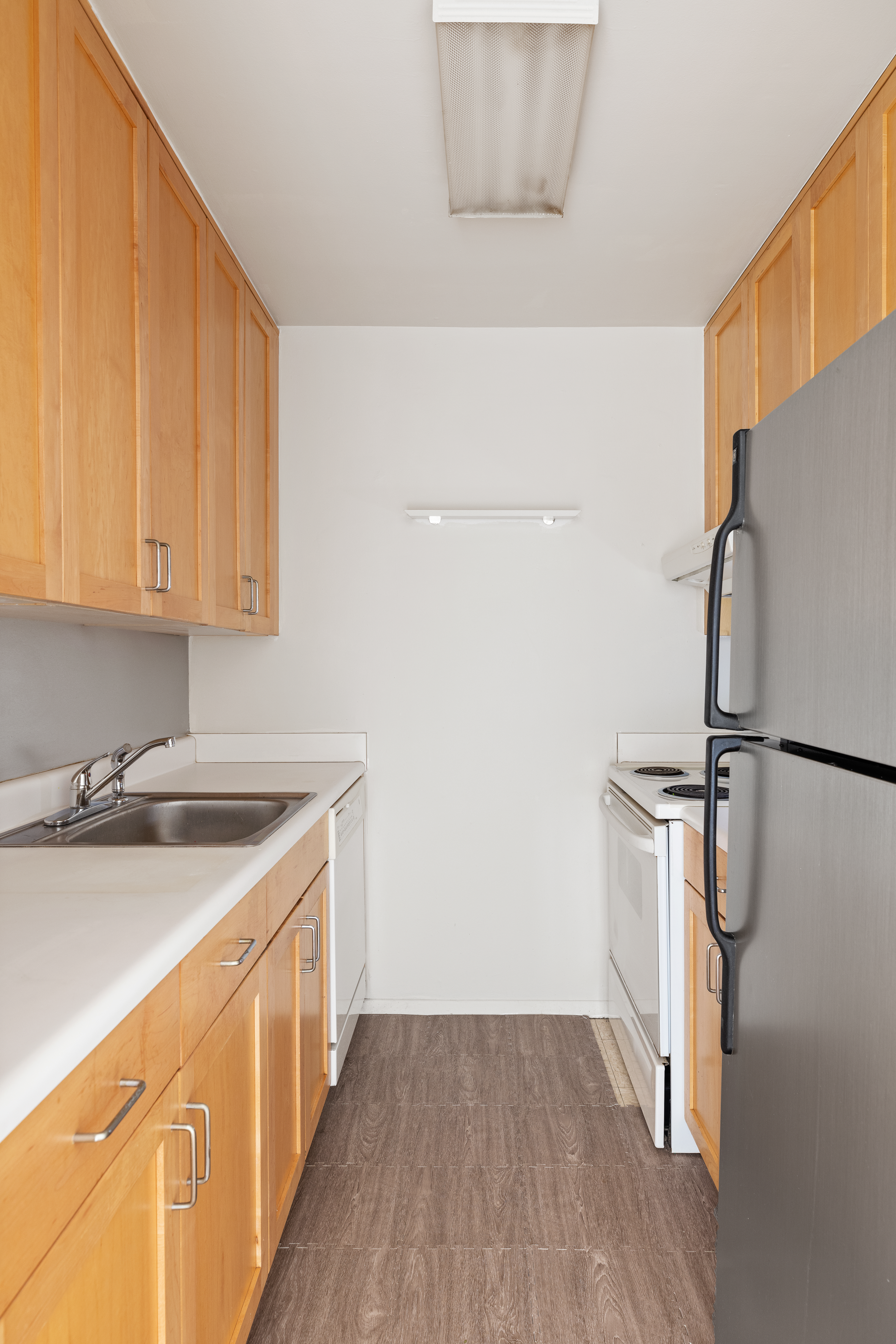 119 Morton Street, Unit 3A Manhattan, NY 10014 - Photo 3 of 7 a kitchen with a sink a refrigerator freezer a washer and dryer with wooden floor