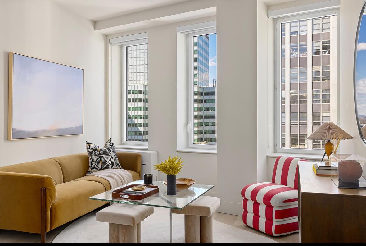 55 Broad Street, Unit 3202 Manhattan, NY 10004 - Photo 1 of 11 a living room with furniture and windows