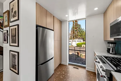 a kitchen with stainless steel appliances granite countertop a refrigerator and a stove top oven
