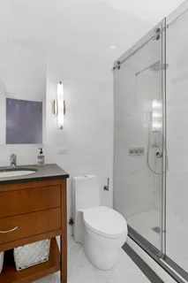 a bathroom with a sink a toilet and shower