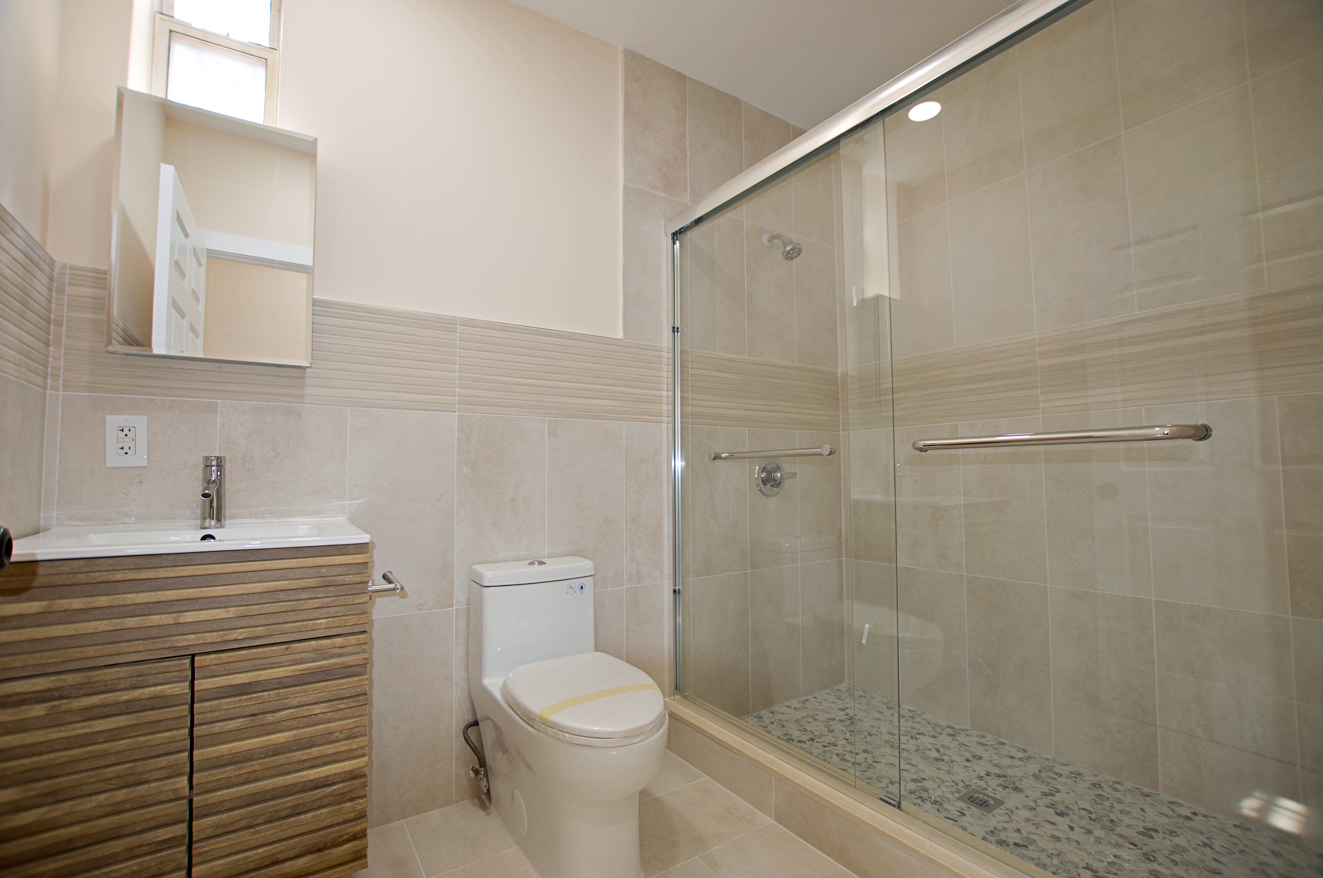 220 Madison Street, Unit 1A Brooklyn, NY 11216 - Photo 9 of 9 a bathroom with a sink a toilet and shower