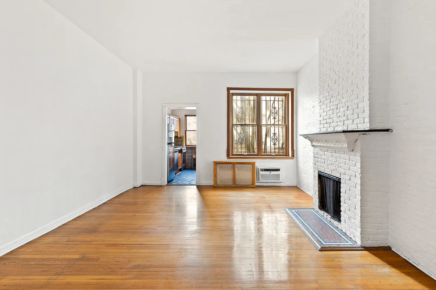 a view of an empty room with a fireplace and a window