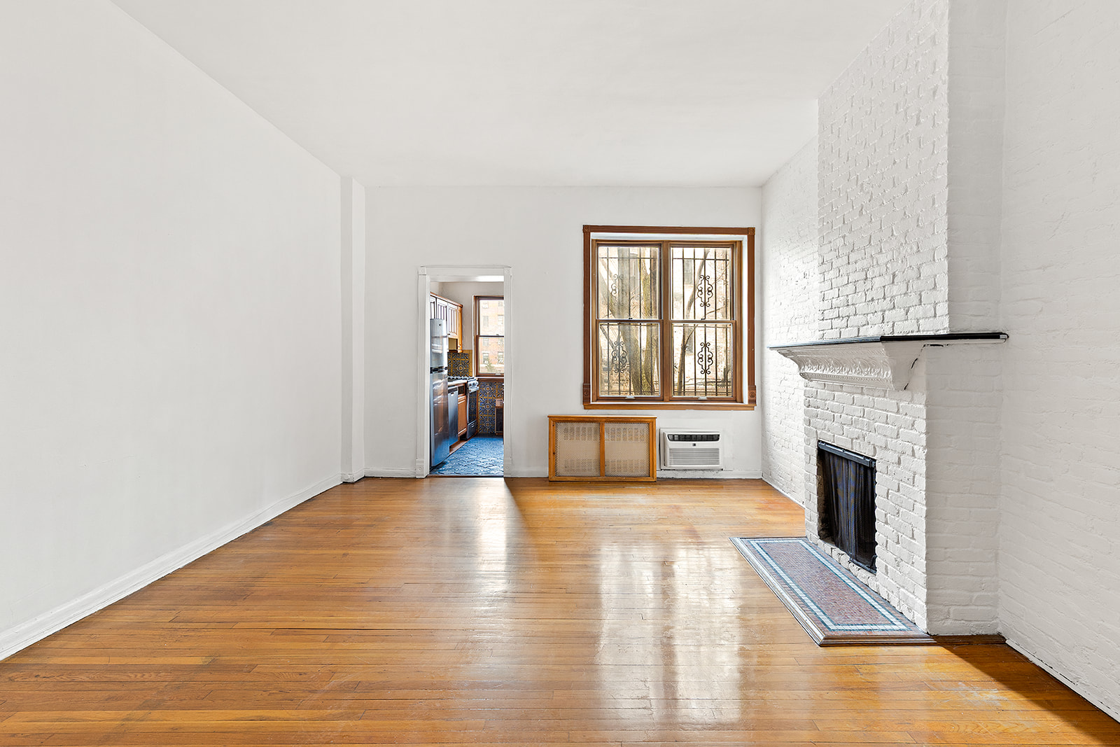 127 West 95th Street Manhattan, NY 10025 - Photo 5 of 15 a view of an empty room with a fireplace and a window
