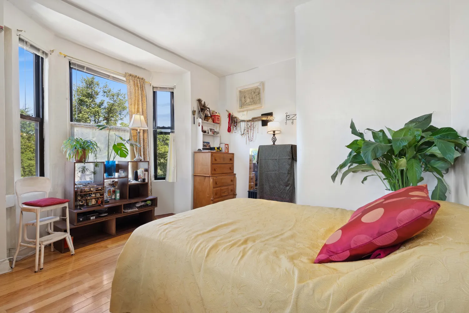 a bedroom with a bed and a potted plant