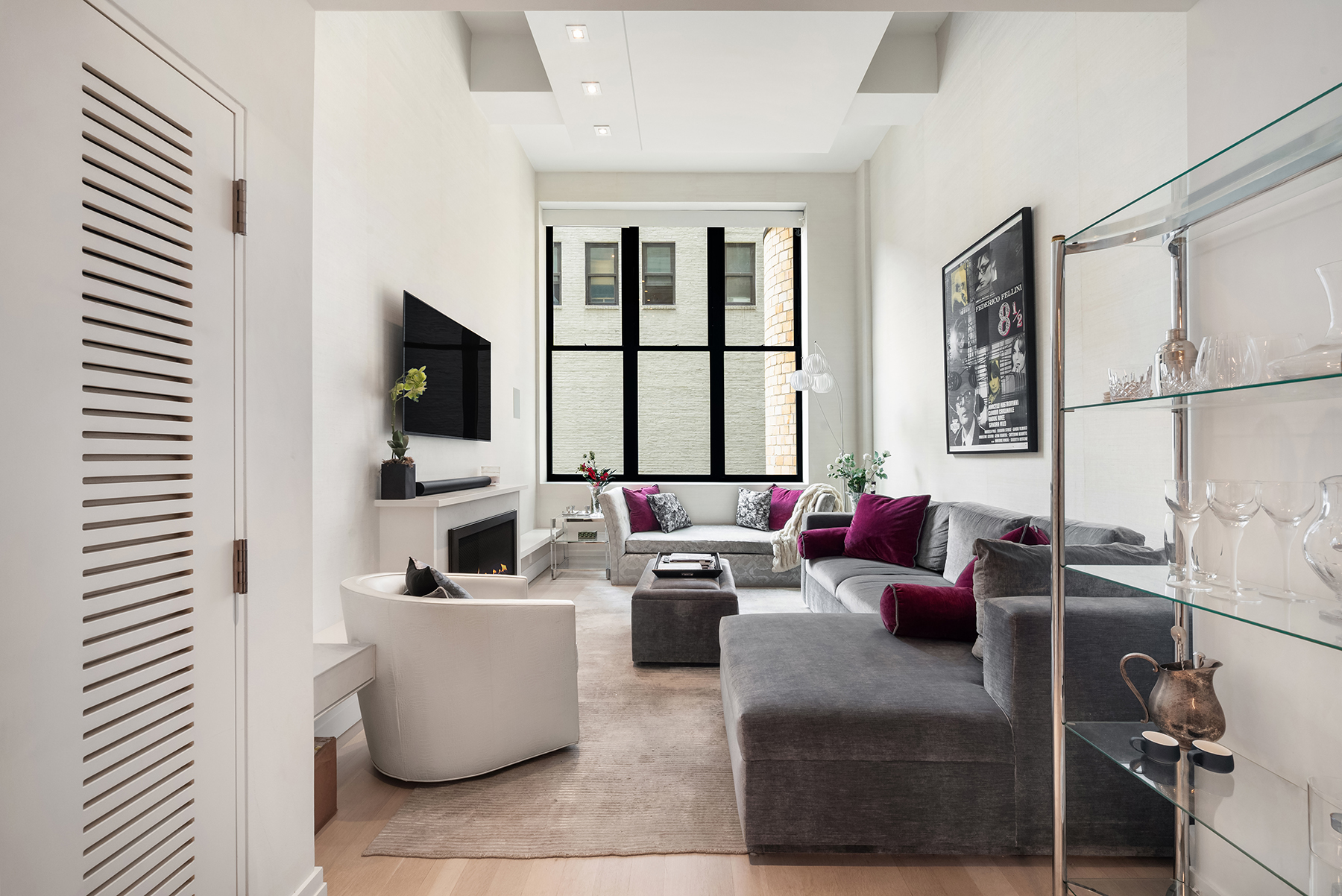 421 Hudson Street, Unit 320 Manhattan, NY 10014 - Photo 2 of 13 a living room with fireplace furniture and a flat screen tv