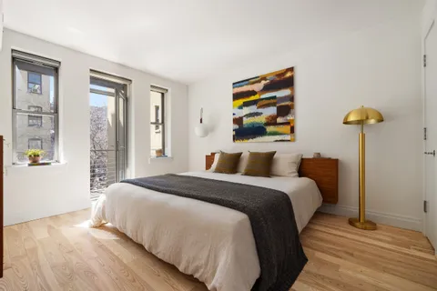a bedroom with a bed and painting on the wall