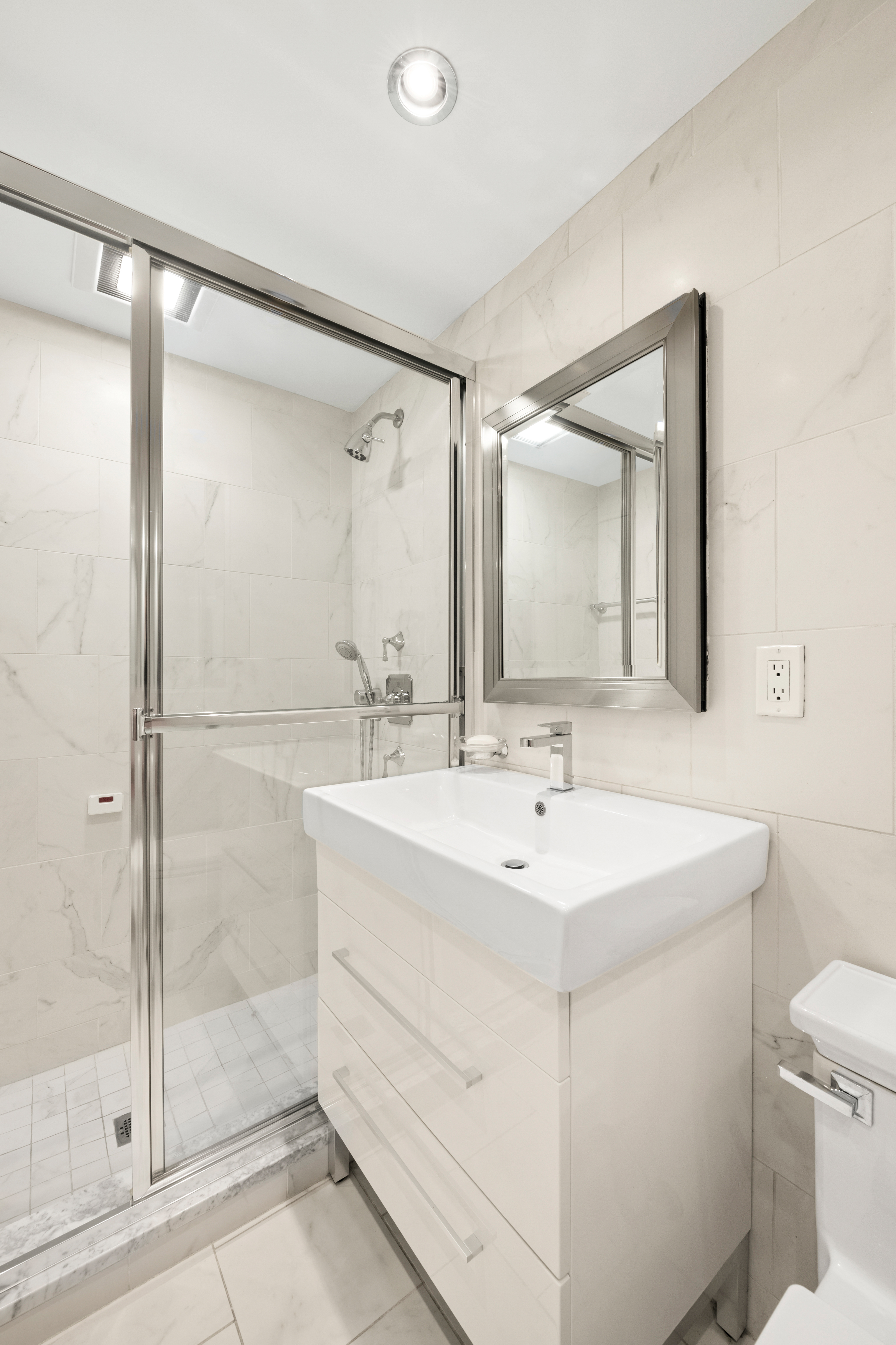 333 East 69th Street, Unit 10J Manhattan, NY 10021 - Photo 6 of 12 a bathroom with a sink toilet and shower