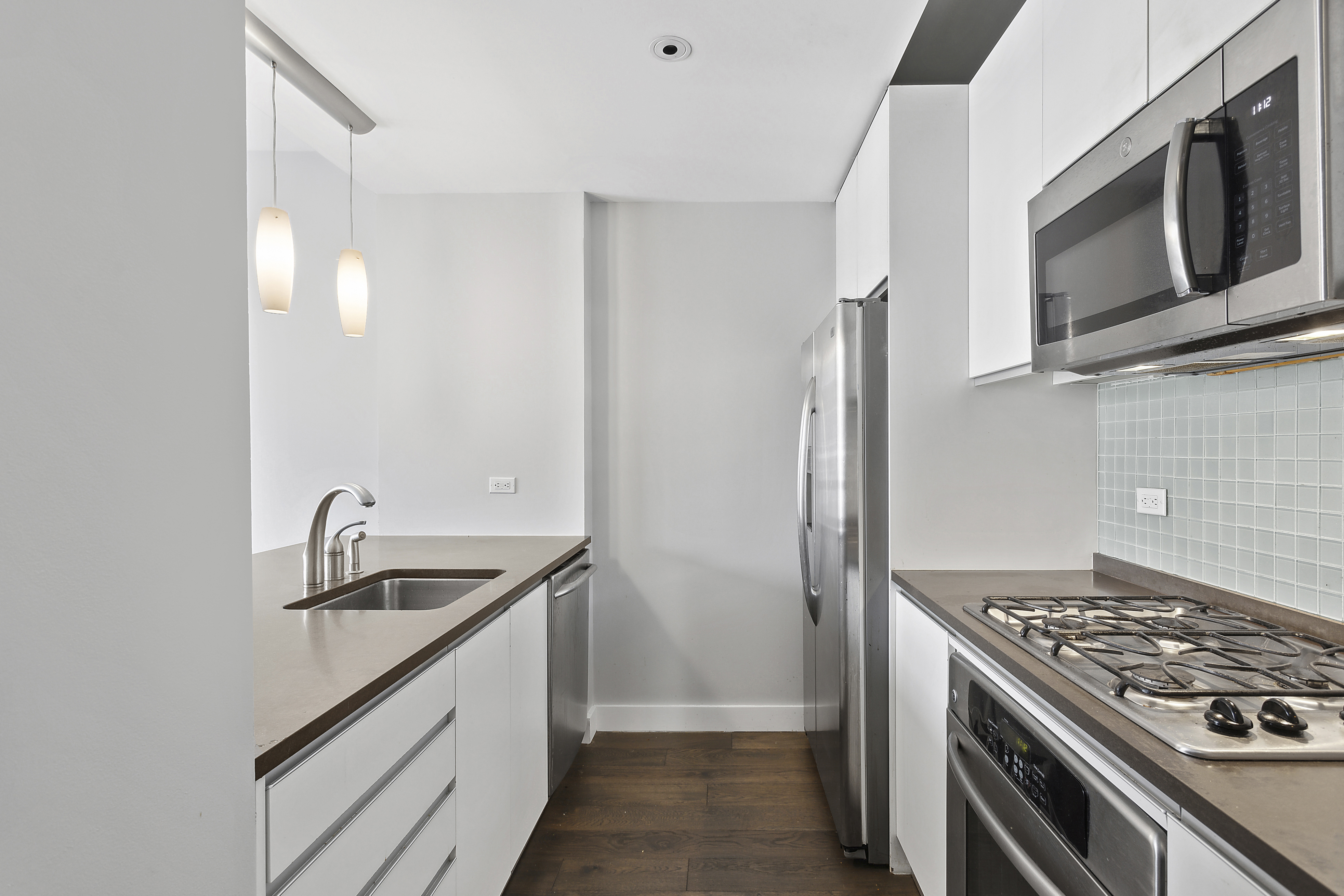306 Gold Street, Unit 7J Brooklyn, NY 11201 - Photo 3 of 4 a kitchen with stainless steel appliances granite countertop a sink stove and refrigerator
