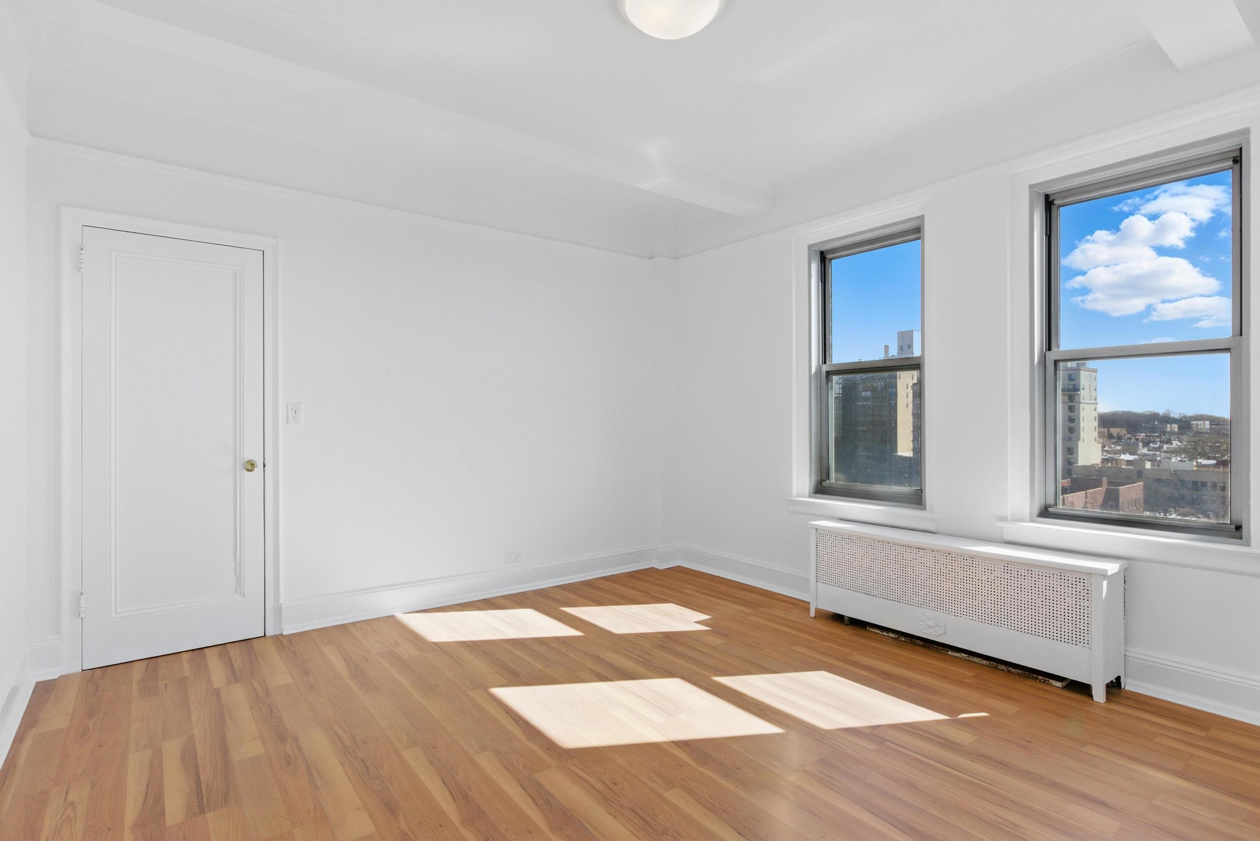1 Plaza Street West, Unit 12C Brooklyn, NY 11217 - Photo 10 of 13 a view of an empty room with a window and wooden floor