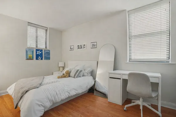 a bedroom with a bed and wooden floor