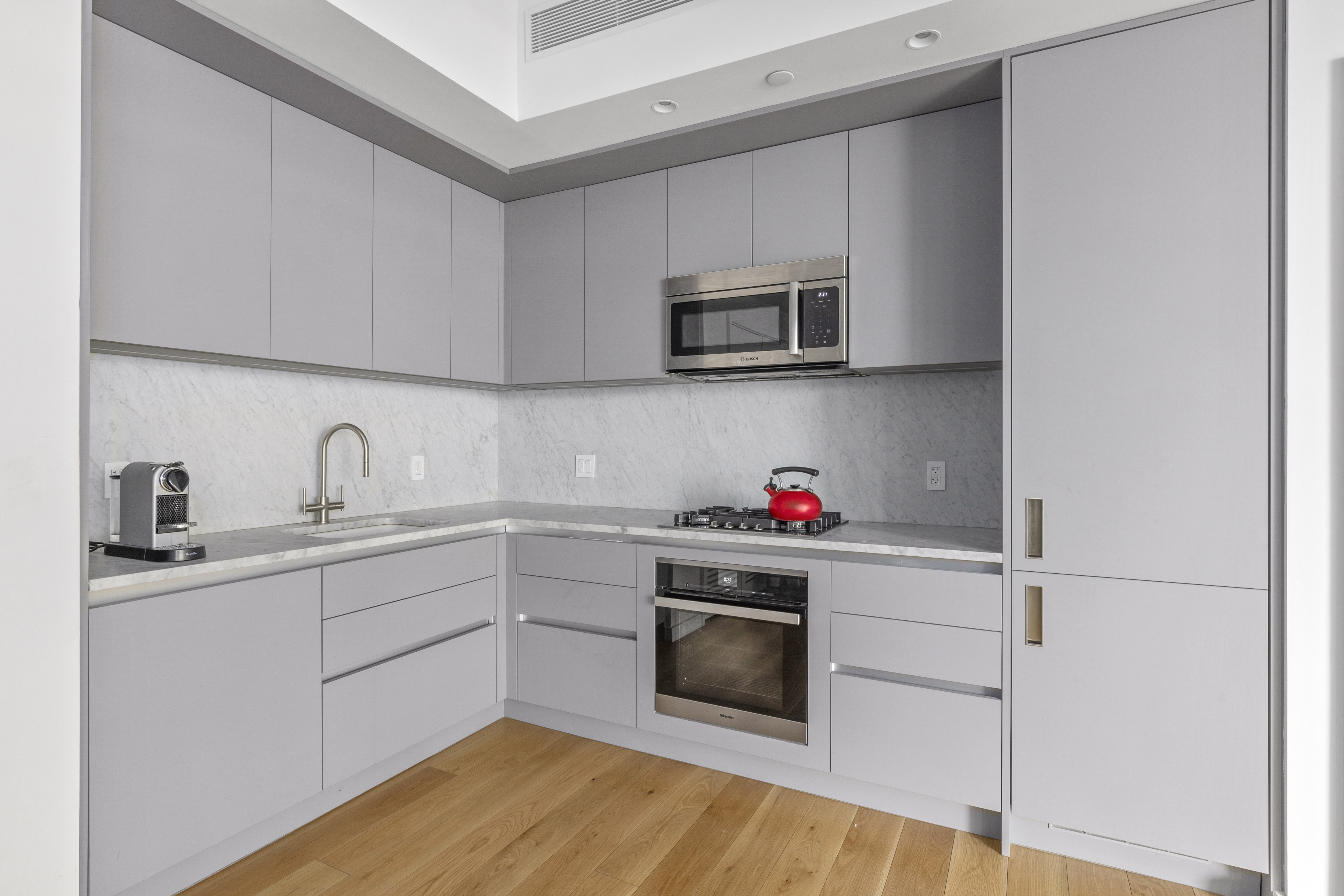 547 West 47th Street, Unit 807 Manhattan, NY 10036 - Photo 3 of 13 a kitchen with stainless steel appliances granite countertop a sink and a microwave