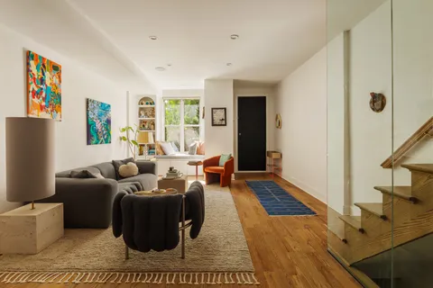 a living room with furniture two window and a flat screen tv