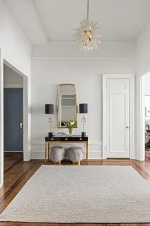 a living room with furniture a chandelier and a rug