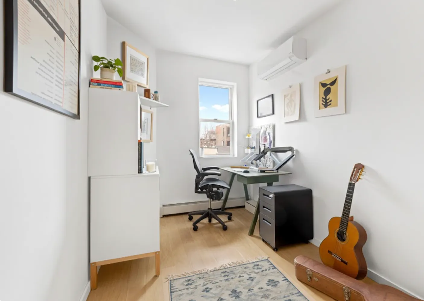 a view of a workspace with furniture and a window