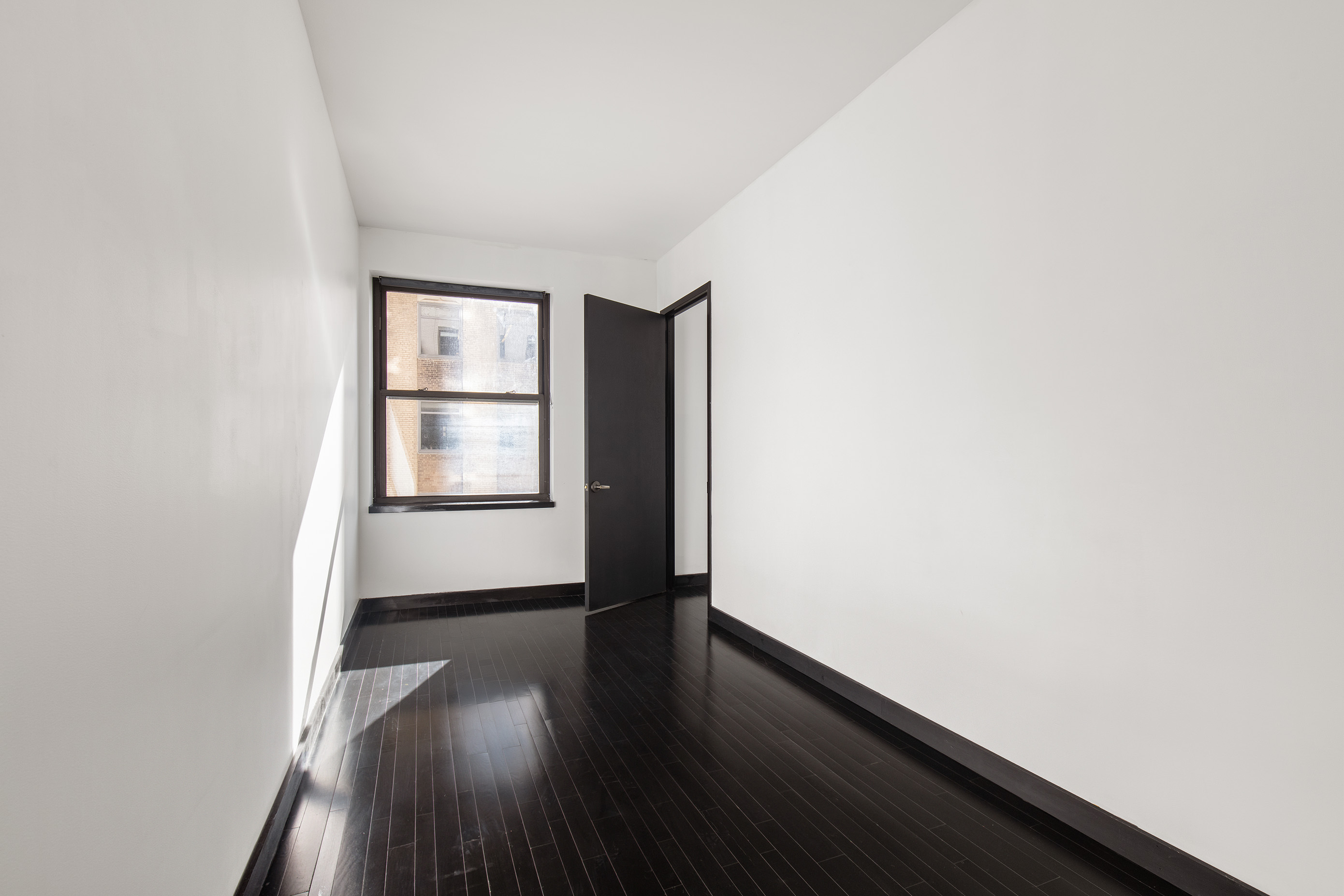 20 Pine Street, Unit 1803 Manhattan, NY 10005 - Photo 3 of 5 an empty room with wooden floor and windows
