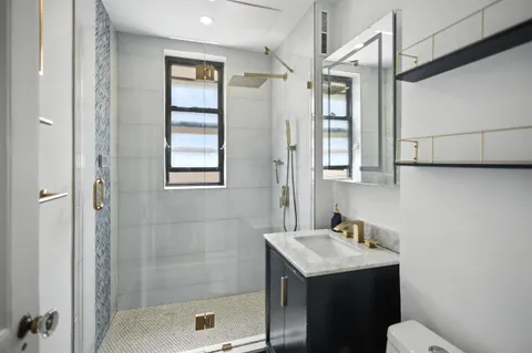 a bathroom with a sink a toilet and shower