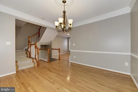 a view of a livingroom with wooden floor and a ceiling fan