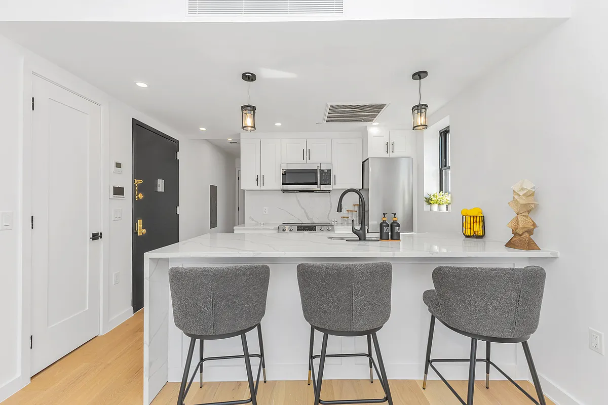 21-10 31st Avenue, Unit 6R Queens, NY 11106 - Photo 7 of 17 a kitchen with stainless steel appliances a sink and cabinets