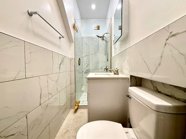 a bathroom with a sink a toilet and shower