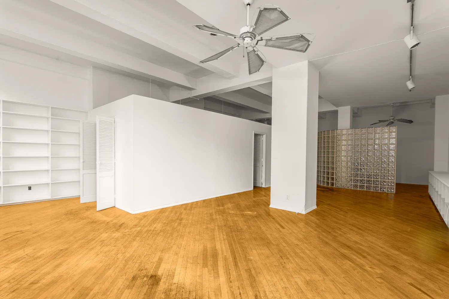 a view of empty room with cabinet and ceiling fan