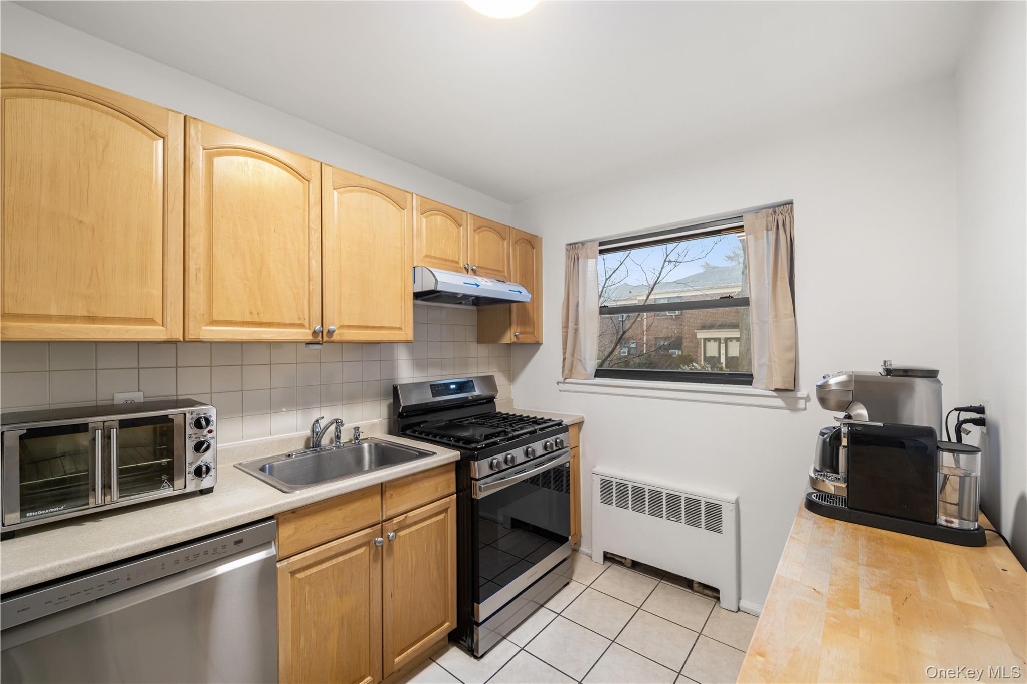 217-14 73rd Avenue, Unit 1 Queens, NY 11364 - Photo 17 of 19 a kitchen with stainless steel appliances a stove microwave and sink