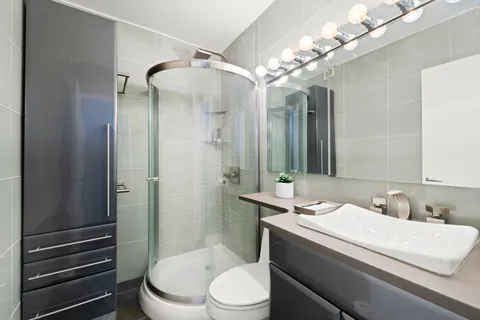 a bathroom with a sink a toilet and shower