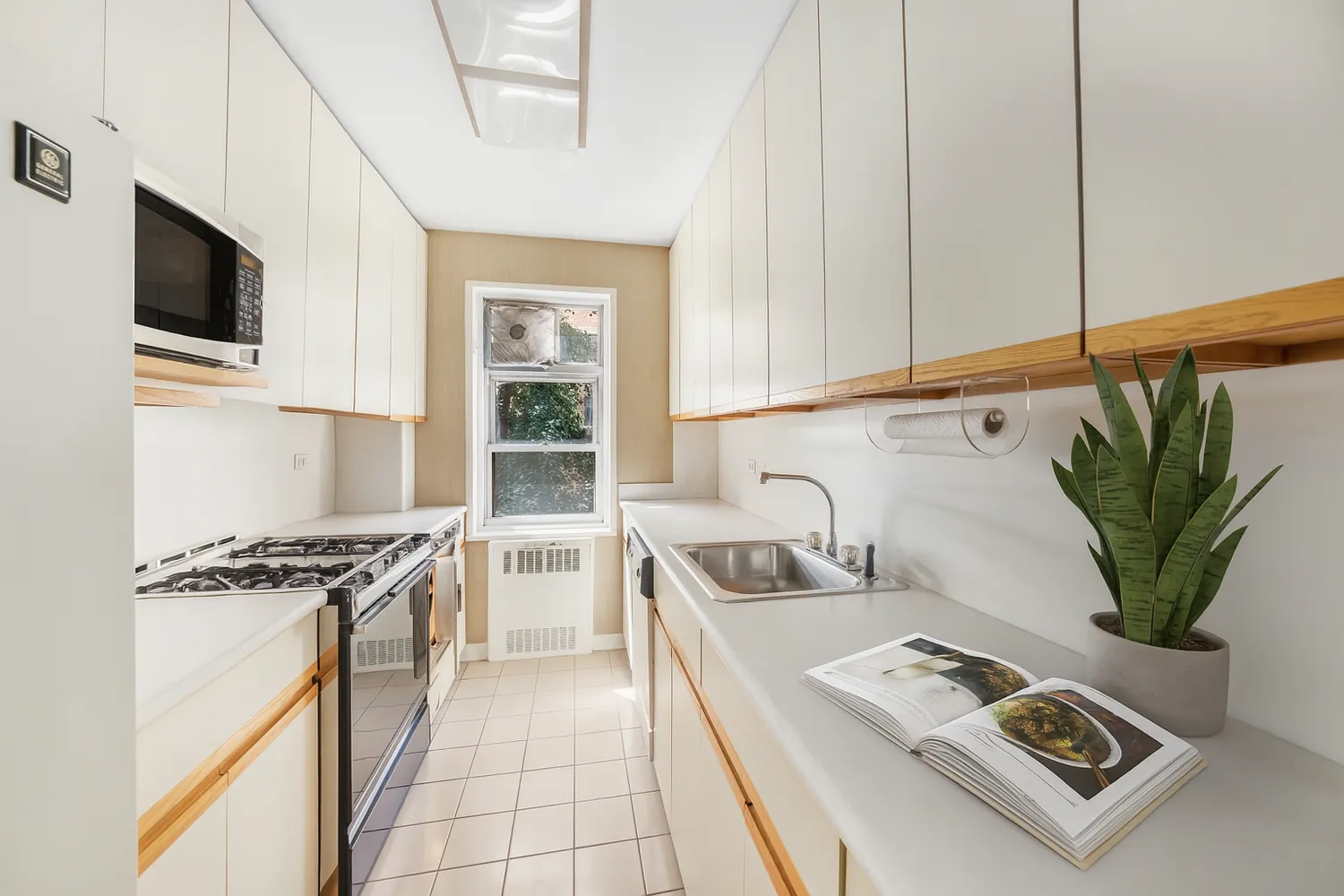 a kitchen with stainless steel appliances a sink a stove cabinets and a window