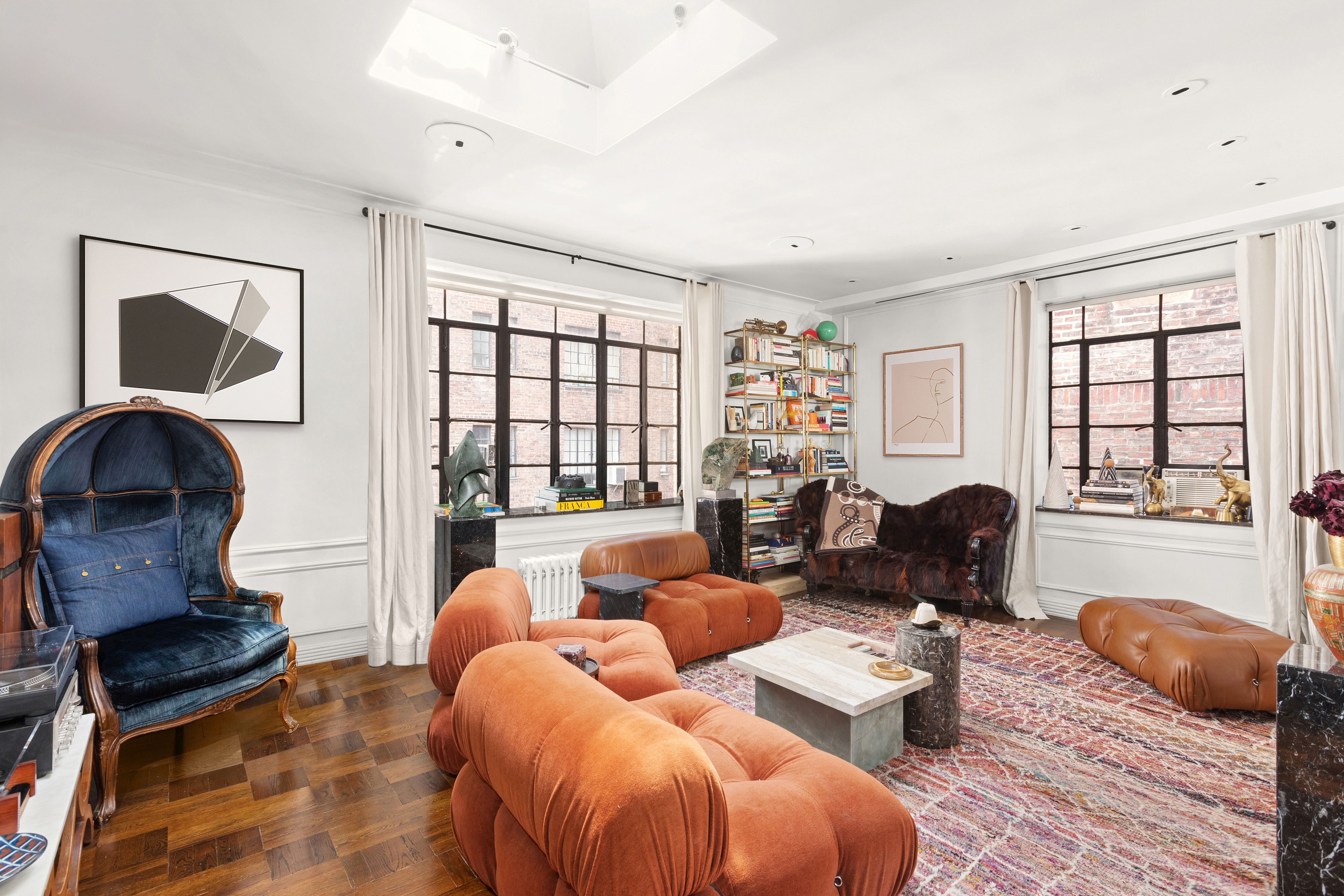a living room with furniture fireplace and large windows