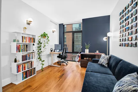 a living room with furniture and a book shelf