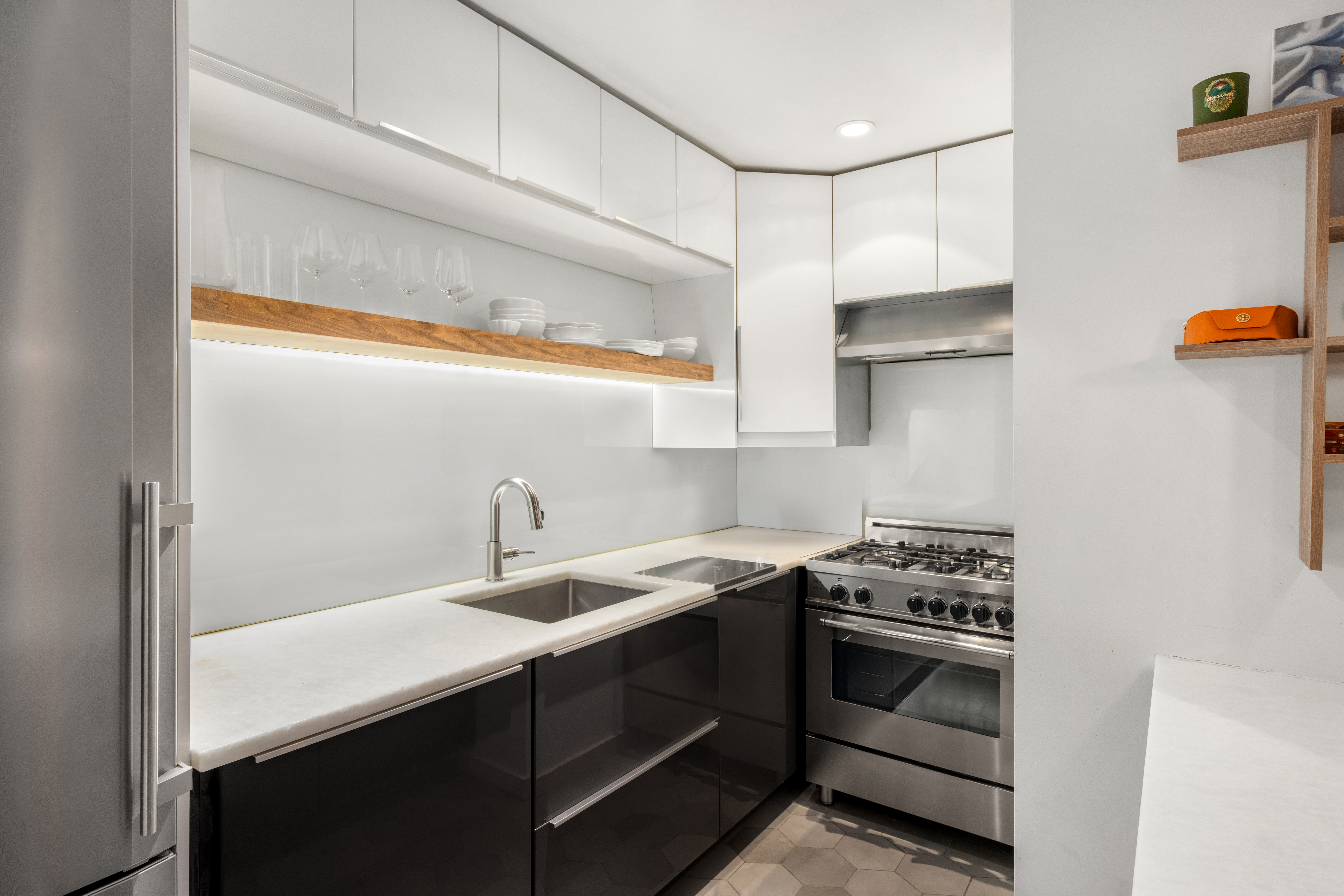 49 East 12th Street, Unit 2C Manhattan, NY 10003 - Photo 5 of 8 a kitchen with stainless steel appliances a sink stove and cabinets