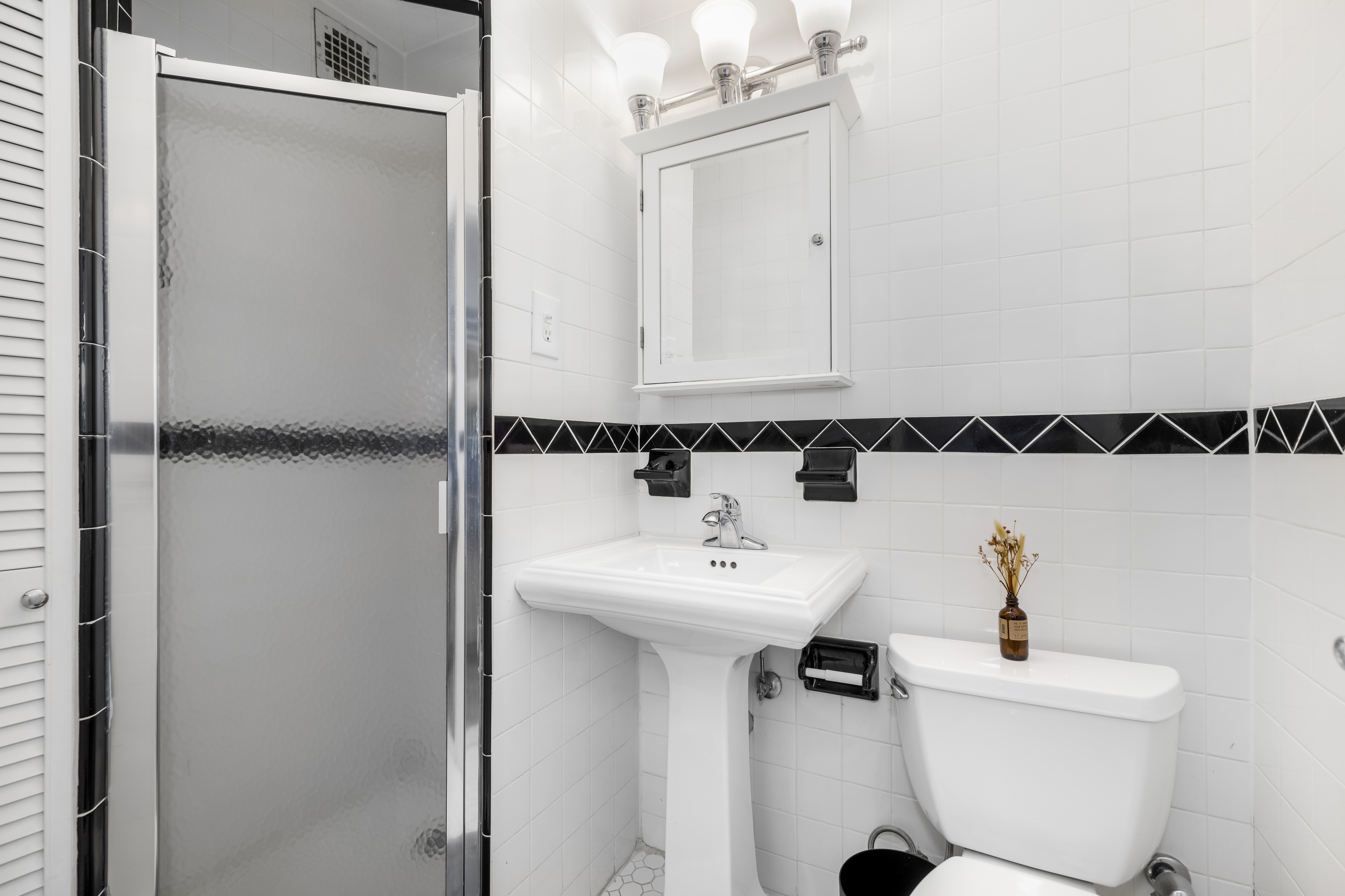 165 Christopher Street, Unit 3A Manhattan, NY 10014 - Photo 7 of 8 a bathroom with a sink a mirror and toilet