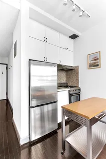 a kitchen with granite countertop a refrigerator and a sink