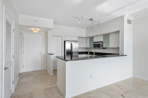 a kitchen with stainless steel appliances granite countertop a refrigerator and a sink