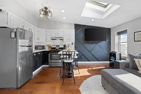 a kitchen with stainless steel appliances kitchen island granite countertop a refrigerator and a stove top oven