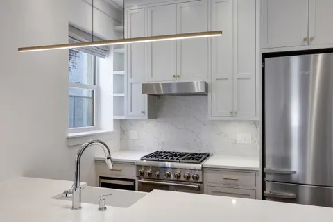 a kitchen with stainless steel appliances granite countertop a refrigerator and a stove