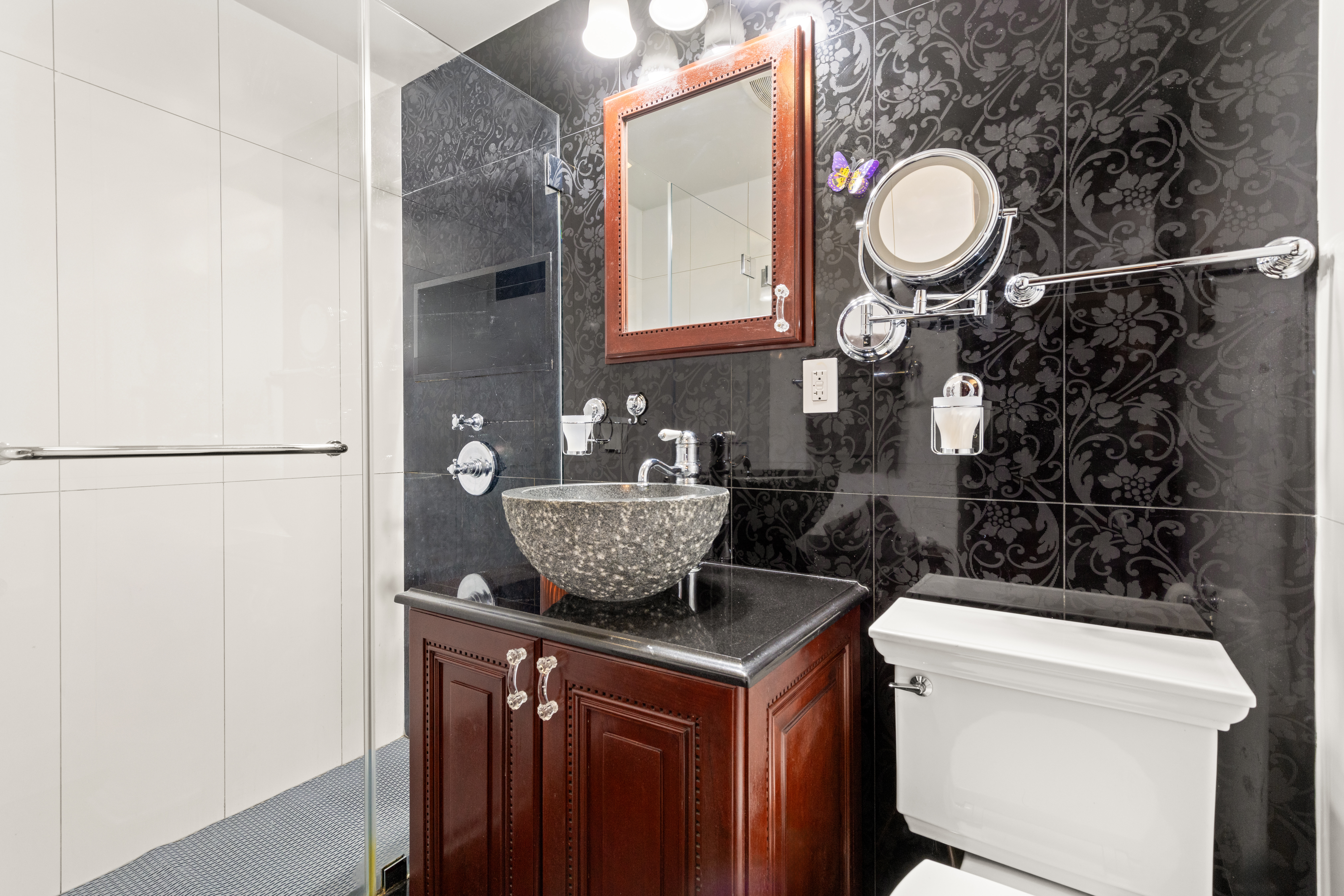 575 Park Avenue, Unit 108 Manhattan, NY 10065 - Photo 10 of 18 a bathroom with a granite countertop sink a toilet and a mirror