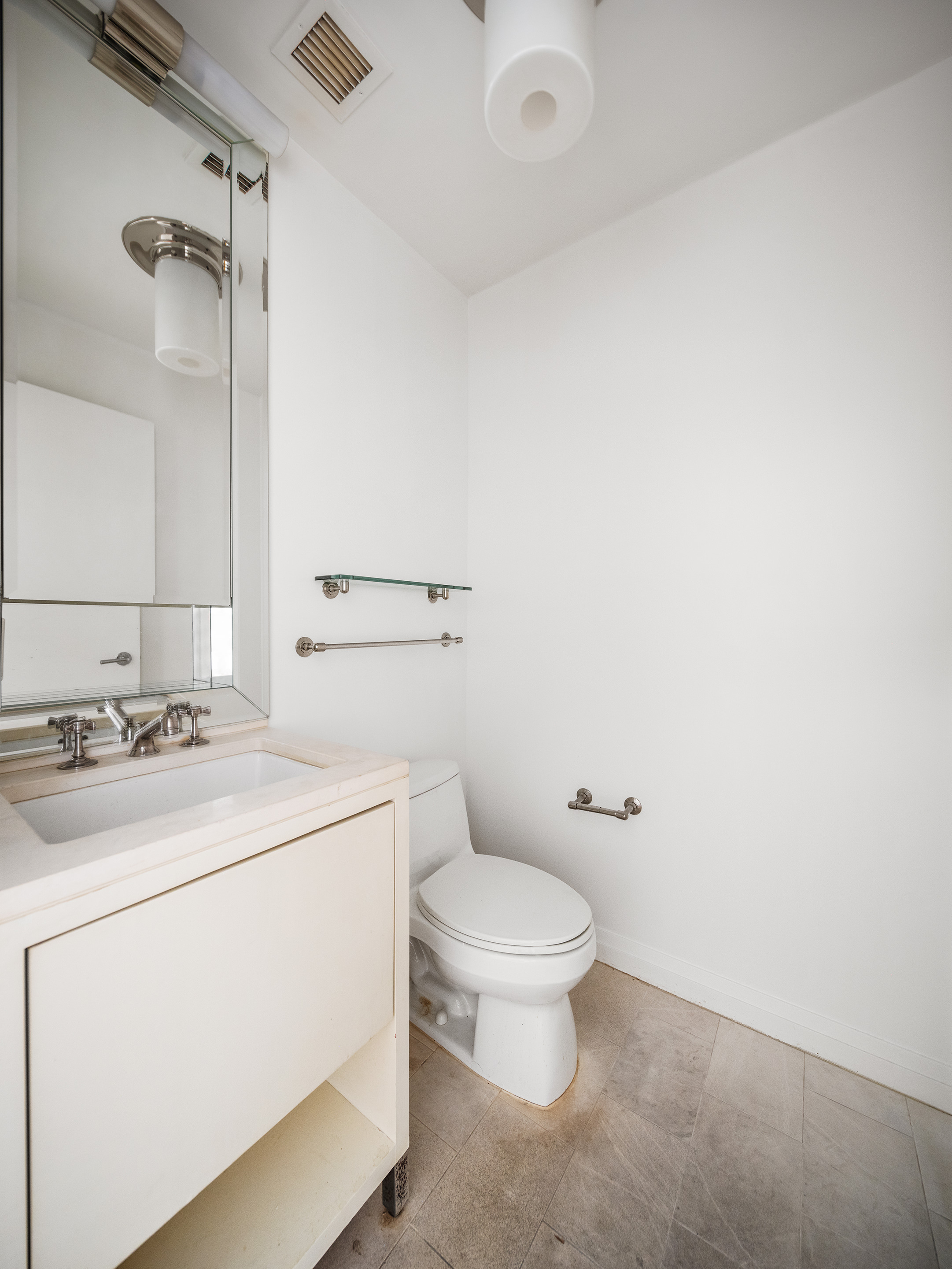 55 Wall Street, Unit 540 Manhattan, NY 10005 - Photo 8 of 10 a bathroom with a sink a toilet and a mirror